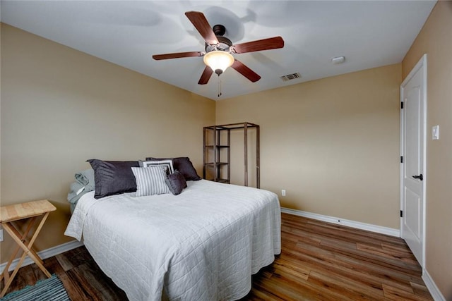 bedroom with dark wood-style flooring, visible vents, and baseboards