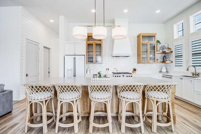 206 Lakeshore St, Port Aransas, TX 78373 - kitchen with white appliances, a sink, decorative backsplash, custom exhaust hood, and white cabinetry