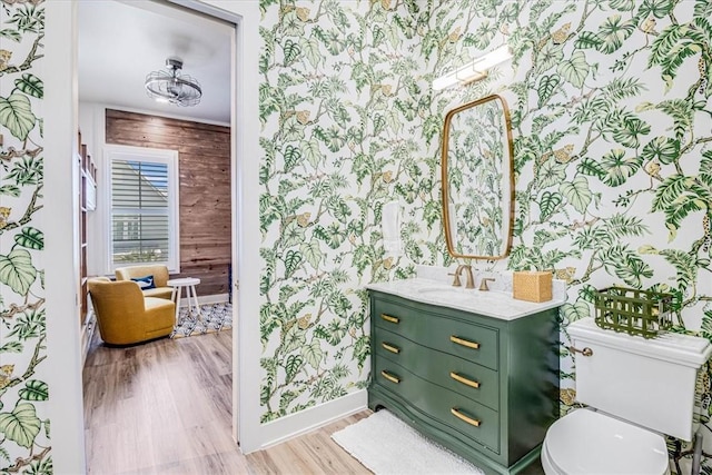 206 Lakeshore St, Port Aransas, TX 78373 - bathroom with wallpapered walls, baseboards, wood finished floors, vanity, and toilet