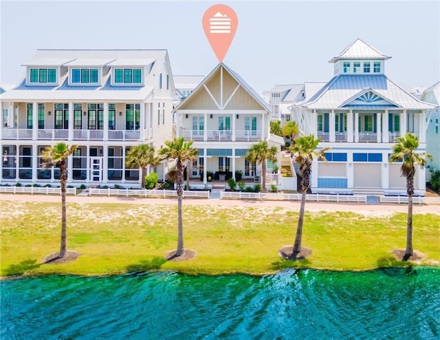 206 Lakeshore St, Port Aransas, TX 78373 - back of property with a standing seam roof, metal roof, a water view, and a yard