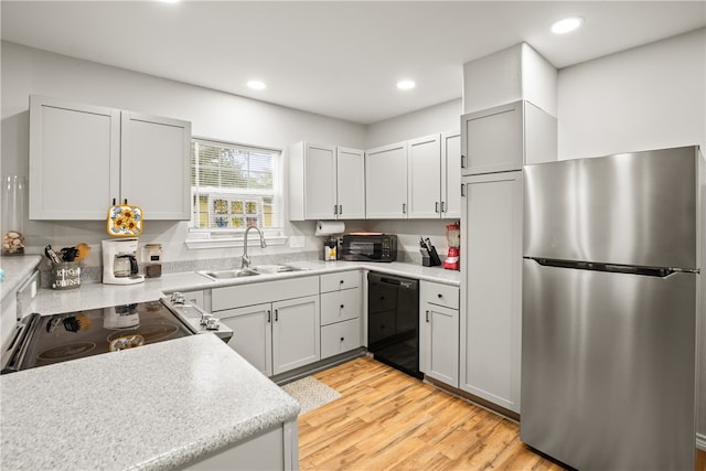 kitchen featuring stainless steel appliances, light hardwood / wood-style floors, and sink