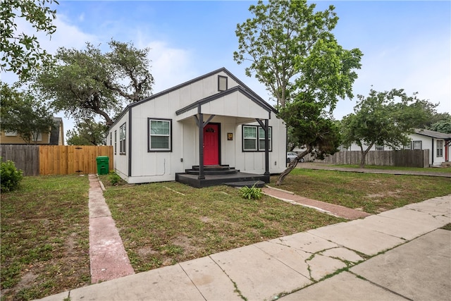 bungalow-style home with a front yard