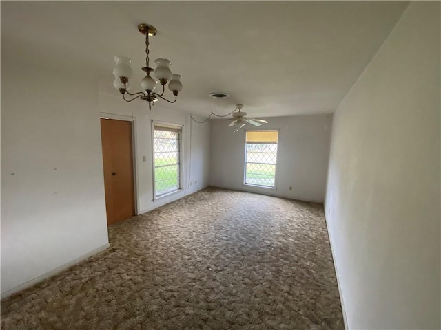 carpeted empty room featuring ceiling fan with notable chandelier