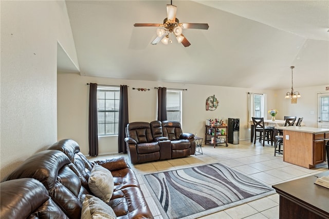 living room with light tile patterned flooring, lofted ceiling, and ceiling fan with notable chandelier