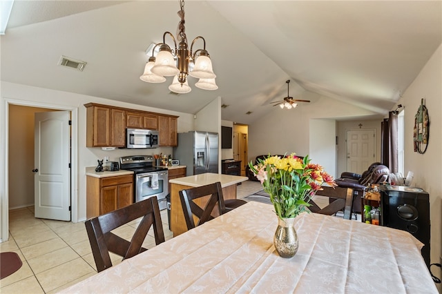 dining room with ceiling fan with notable chandelier, lofted ceiling, and light tile patterned floors