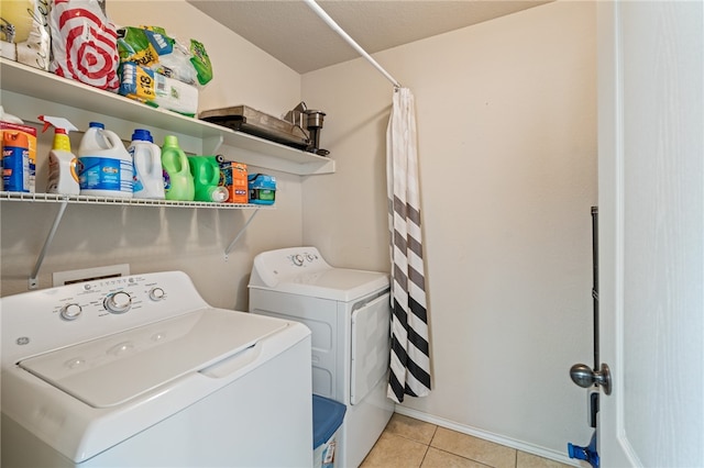 laundry room featuring washing machine and clothes dryer and light tile patterned floors