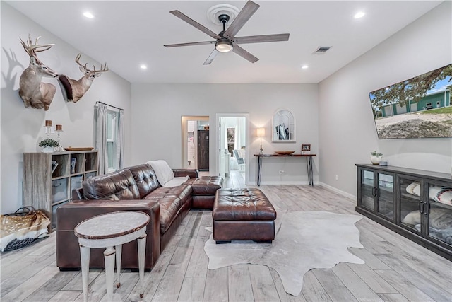 living room with ceiling fan and light hardwood / wood-style flooring