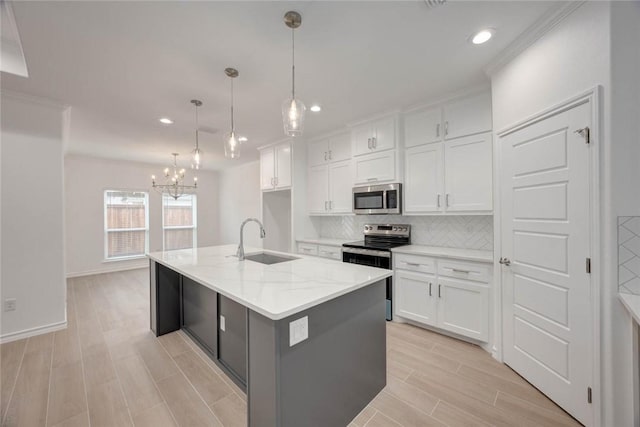 kitchen with pendant lighting, a center island with sink, sink, white cabinetry, and stainless steel appliances