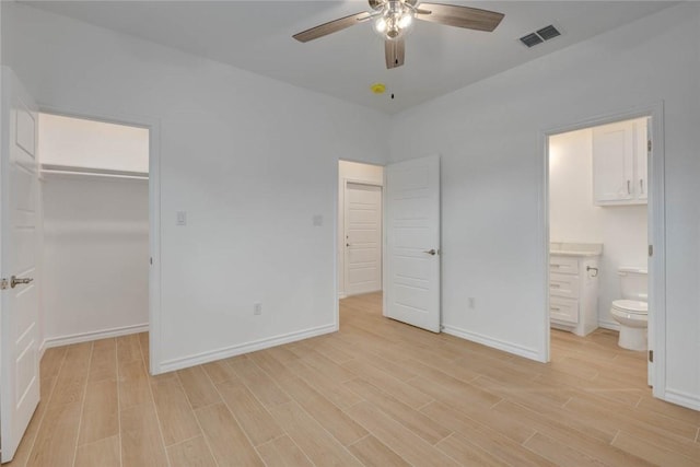 unfurnished bedroom with ceiling fan, light wood-type flooring, a spacious closet, and a closet