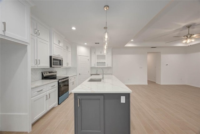 kitchen featuring pendant lighting, stainless steel appliances, white cabinetry, and sink