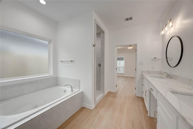 bathroom featuring shower with separate bathtub, vanity, and hardwood / wood-style floors