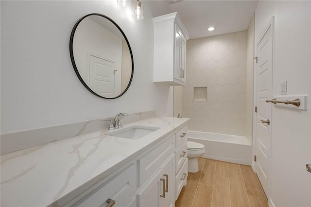 full bathroom with tiled shower / bath, vanity, and toilet