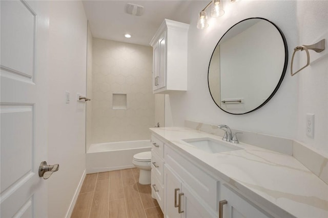 full bathroom with hardwood / wood-style floors, vanity, toilet, and tub / shower combination