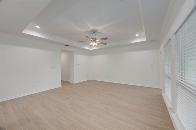 unfurnished room with a tray ceiling, light hardwood / wood-style flooring, and ceiling fan