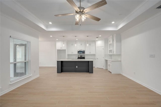 kitchen featuring white cabinetry, a center island, ceiling fan, hanging light fixtures, and tasteful backsplash