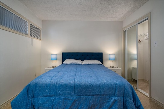 bedroom featuring baseboards, a closet, and a textured ceiling