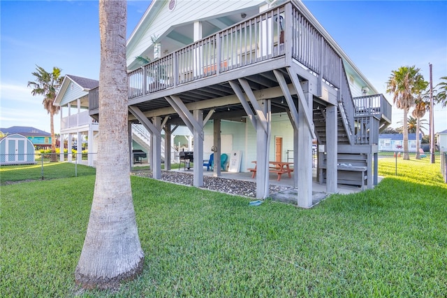 rear view of house with a patio, a deck, and a lawn