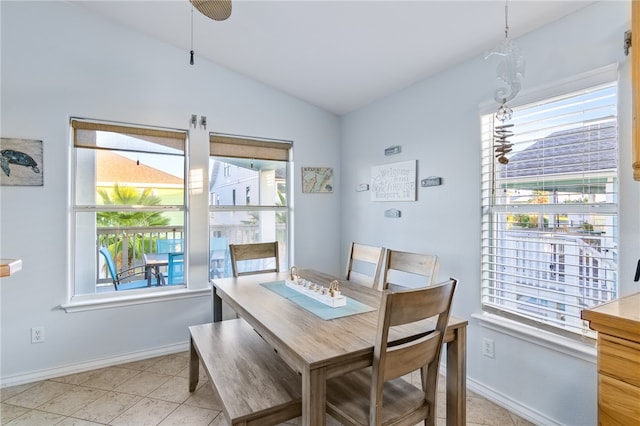 dining space with ceiling fan, plenty of natural light, light tile patterned floors, and vaulted ceiling