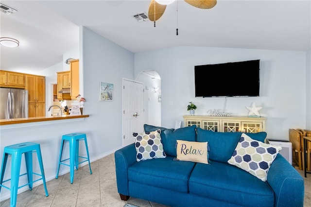 living room with ceiling fan, light tile patterned flooring, lofted ceiling, and sink