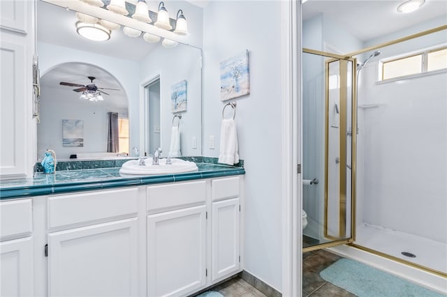 bathroom with walk in shower, vanity, ceiling fan, tile patterned flooring, and toilet