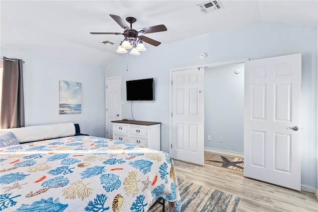 bedroom with ceiling fan, lofted ceiling, and light hardwood / wood-style flooring