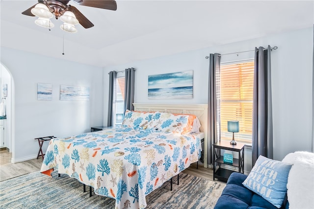 bedroom featuring multiple windows, light hardwood / wood-style floors, and ceiling fan