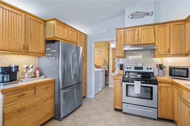 kitchen featuring decorative backsplash, light tile patterned floors, stainless steel appliances, and lofted ceiling