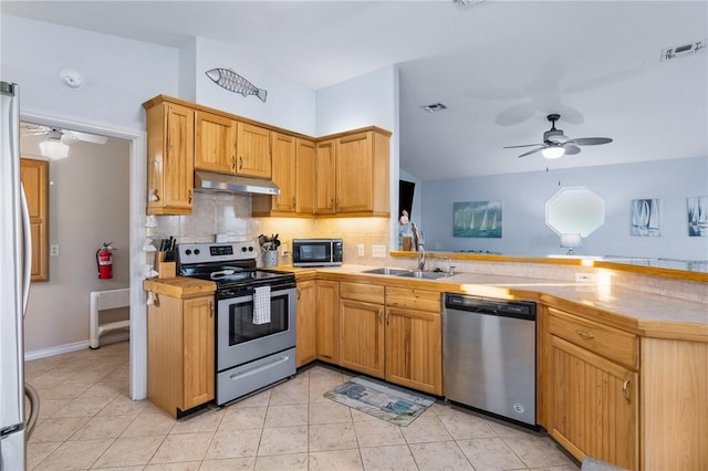 1224 S Live Oak St, Rockport, TX 78382 - kitchen featuring appliances with stainless steel finishes, a ceiling fan, under cabinet range hood, a sink, and lofted ceiling