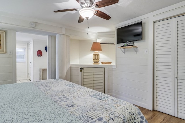 bedroom featuring ceiling fan, a closet, and light hardwood / wood-style flooring