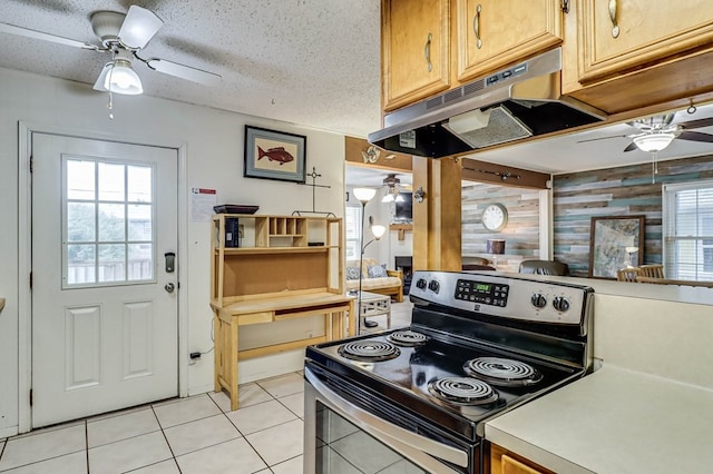 kitchen featuring a textured ceiling, electric range, plenty of natural light, and wood walls