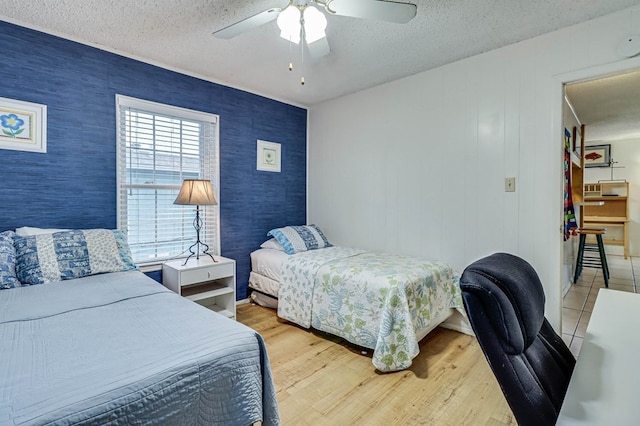 bedroom featuring a textured ceiling, light hardwood / wood-style floors, and ceiling fan