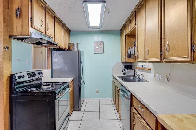 kitchen with sink, light tile patterned flooring, stainless steel appliances, and a textured ceiling