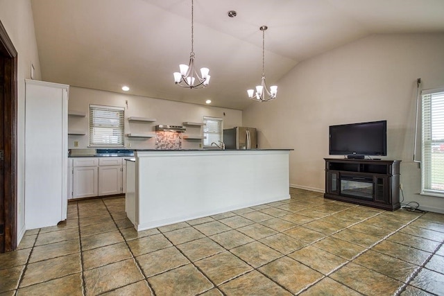 kitchen with vaulted ceiling, white cabinets, a chandelier, stainless steel refrigerator, and decorative light fixtures