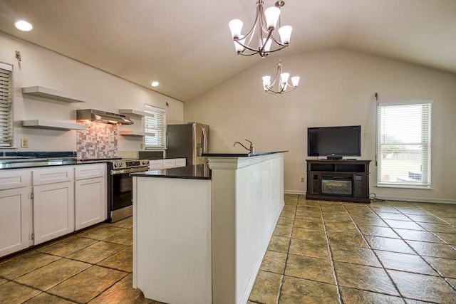 kitchen with stainless steel appliances, a center island with sink, vaulted ceiling, white cabinetry, and decorative light fixtures