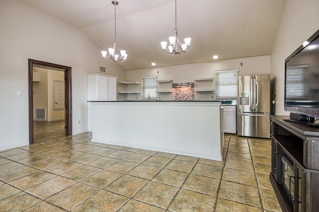 kitchen featuring white cabinets, a chandelier, vaulted ceiling, and stainless steel fridge with ice dispenser