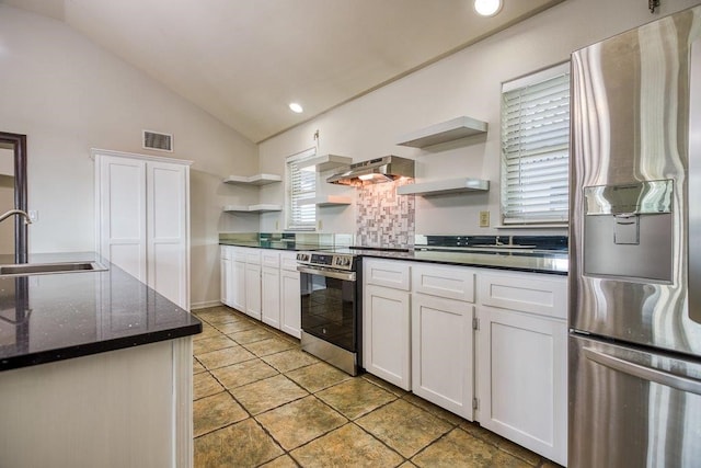 kitchen featuring vaulted ceiling, white cabinets, sink, backsplash, and appliances with stainless steel finishes