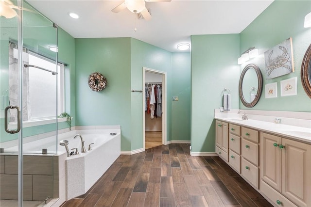 bathroom featuring a garden tub, a stall shower, a sink, and wood finish floors