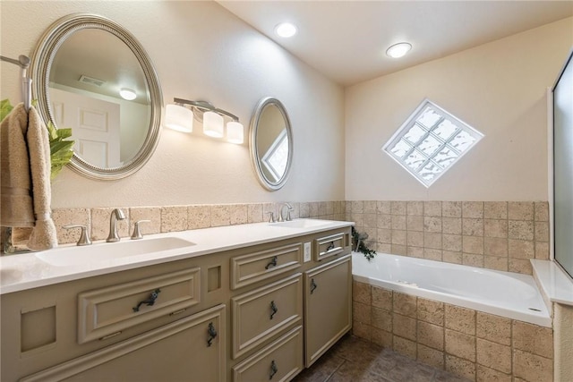 full bath featuring a garden tub, double vanity, tile patterned flooring, and a sink