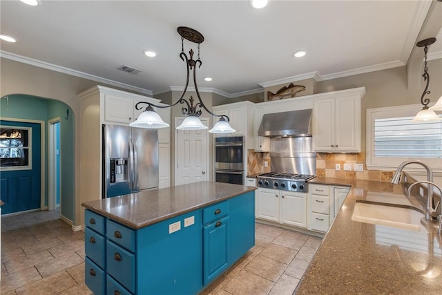 kitchen featuring arched walkways, extractor fan, stainless steel appliances, blue cabinetry, and a sink