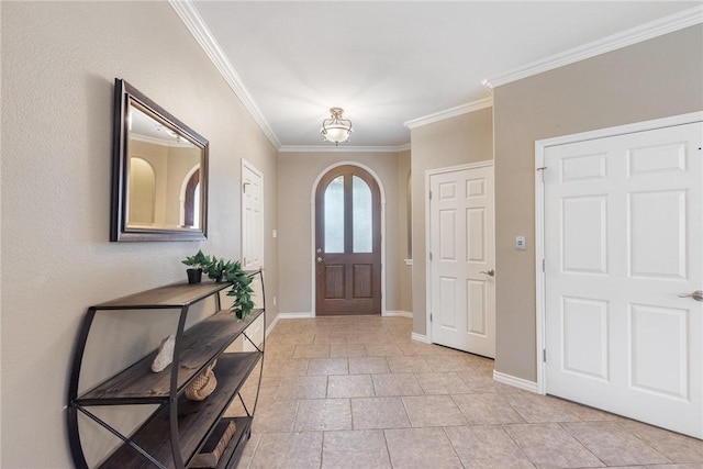 entrance foyer with baseboards, arched walkways, and crown molding