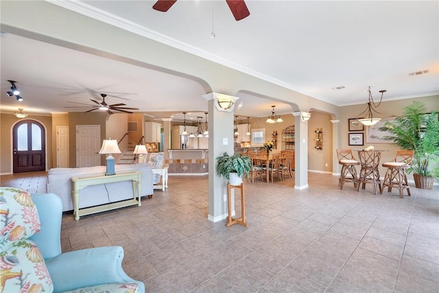 living room with arched walkways, ceiling fan, crown molding, visible vents, and ornate columns