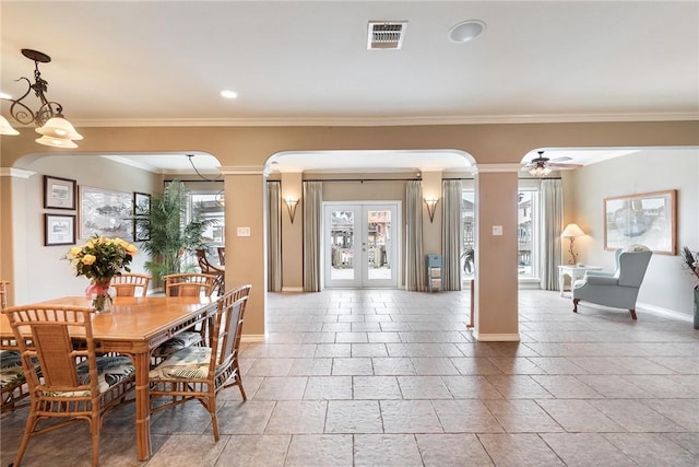 dining area with arched walkways, visible vents, baseboards, french doors, and ornamental molding