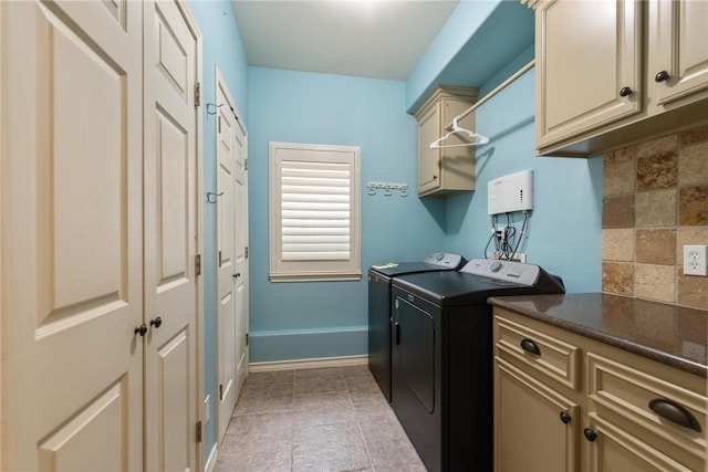 laundry area featuring light tile patterned floors, independent washer and dryer, cabinet space, and baseboards