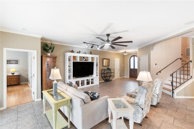 living room featuring visible vents, arched walkways, a ceiling fan, stairs, and crown molding