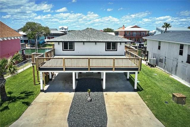 140 Port Saint Claire, Aransas Pass, TX 78336 - back of house with a carport, driveway, cooling unit, a shingled roof, and a wooden deck