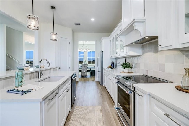 121 Frontside Dr, Corpus Christi, TX 78373 - kitchen with premium appliances, a sink, white cabinetry, an island with sink, and light countertops