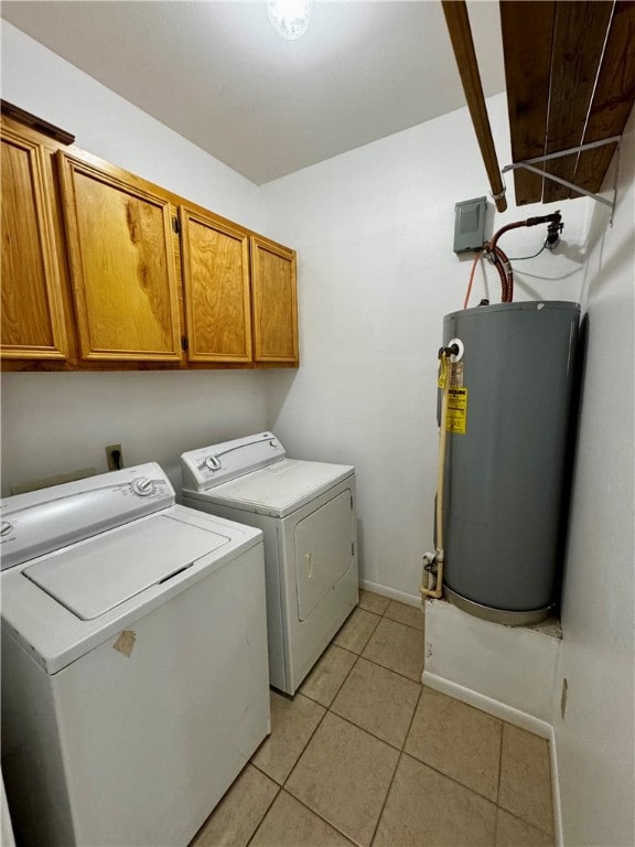 laundry room featuring light tile patterned flooring, water heater, cabinets, and washer and clothes dryer