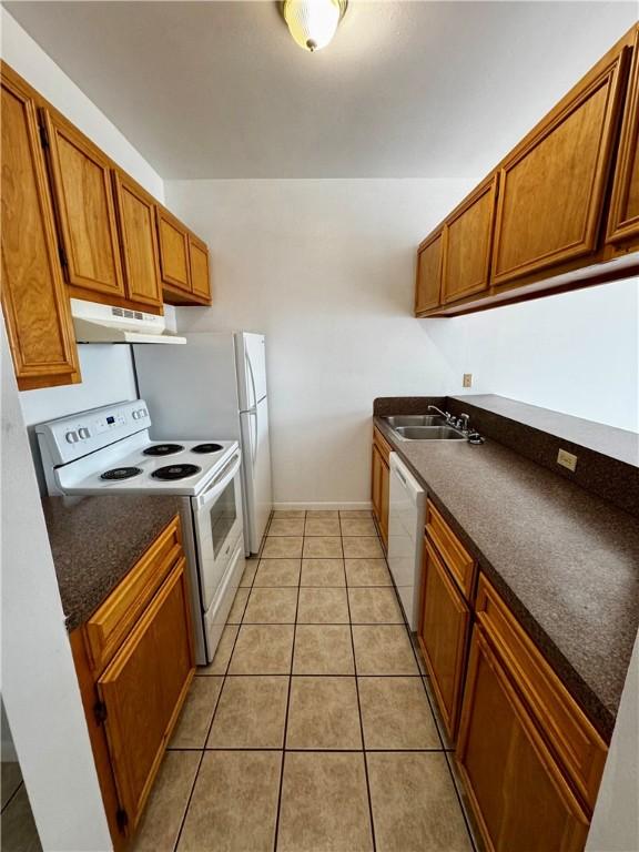 13958 Fortuna Bay Dr Unit C, Corpus Christi, TX 78418 - kitchen with white appliances, under cabinet range hood, dark countertops, and brown cabinets