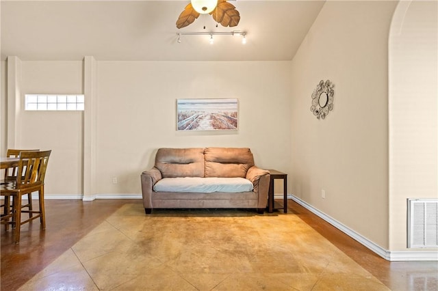 sitting room with visible vents, baseboards, concrete floors, and a ceiling fan