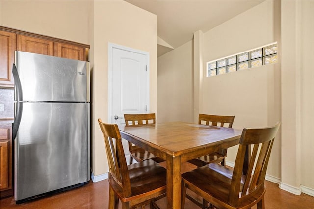 dining room featuring baseboards and vaulted ceiling